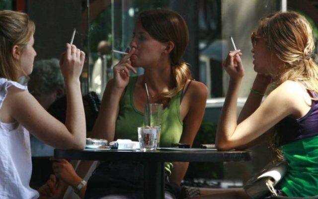 De jeunes Israéliennes fument des cigarettes dans un café du centre de Tel Aviv. (Crédit : Kobi Gideon/Flash90) De jeunes Israéliennes fument des cigarettes dans un café du centre de Tel Aviv. (Crédit : Kobi Gideon/Flash90)