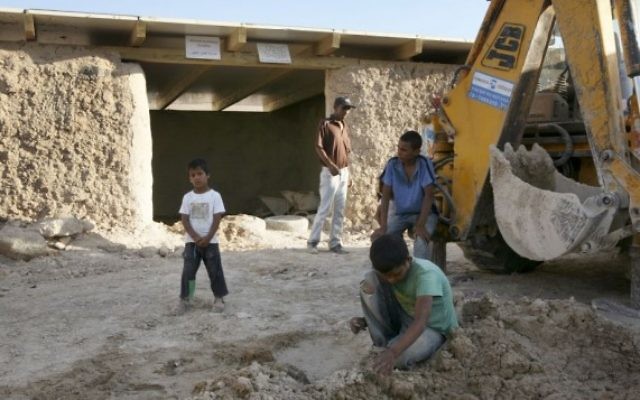 Des enfants bédouins jouent près d'un tracteur devant une école dans le désert de Judée, au sud de l'implantation de Maale Adumim, le 13 juillet 2009. (Crédit : Matanya Tausig/Flash90)