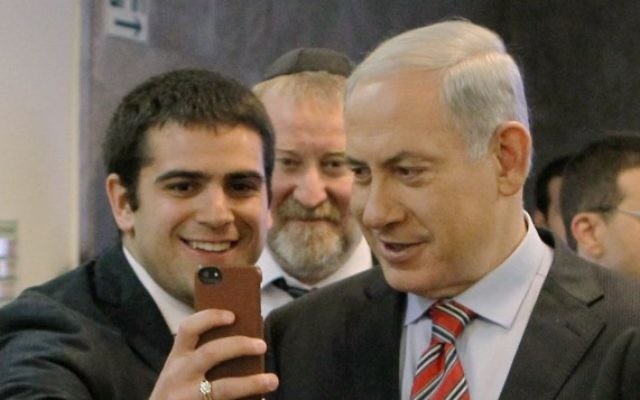 La Premier ministre Benjamin Netanyahu pose pour un selfie avec un étudiant le 30 mars 2014 (Danny Meron/POOL/Flash90)