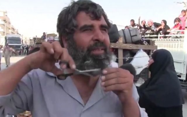 Un Syrien coupe sa barbe après que sa ville de Manbij a été libéré du contrôle de l'Etat islamique, le 13 août 2016 (Crédit : Capture d'écran / K24) Un Syrien coupe sa barbe après que sa ville de Manbij a été libéré du contrôle de l'Etat islamique, le 13 août 2016 (Crédit : Capture d'écran / K24)