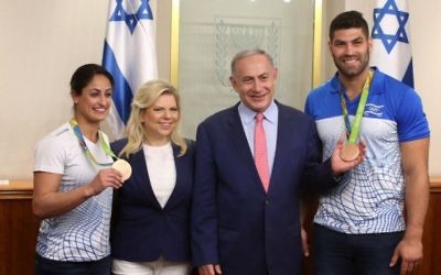 Le Premier ministre Benjamin Netanyahu et son épouse Sara avec les judokas israéliens médaillés olympiques Or Sasson et Yarden Gerbi lors d'une rencontre avec la délégation sportive pour les 2016 Jeux Olympiques de Rio, au bureau du Premier ministre à Jérusalem, le 17 août 2016. (Amit Shabi / Piscine)
