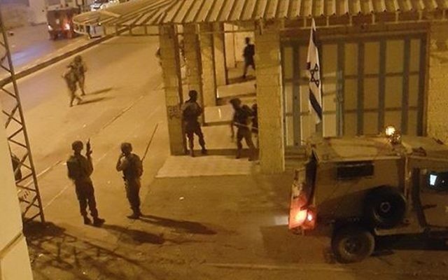 Cette image a été publiée par des utilisateurs de réseaux sociaux palestiniens. Elle montrerait des soldats israéliens devant les bureaux d'une radio de Hébron en novembre 2015. (Crédit : Facebook) Cette image a été publiée par des utilisateurs de réseaux sociaux palestiniens. Elle montrerait des soldats israéliens devant les bureaux d'une radio de Hébron en novembre 2015. (Crédit : Facebook)
