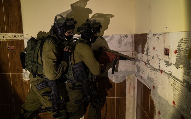 Des soldats israéliens se préparent à démolir la maison de Mohammed Omaireh, qui a avoué faire partie de la cellule terroriste qui a tué le rabbin Miki Mark. Le bâtiment a été détruit dans le village de Dura, en Cisjordanie, le 30 août 2016. (Crédit : porte-parole de l'armée israélienne)