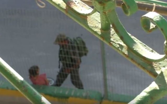 Un garde-frontière israélien empêche une petite fille palestinienne de reprendre son vélo en le bloquant avec le pied, à Hébron, le 25 juillet 2016. (Crédit : capture d'écran YouTube/B'Tselem) Un garde-frontière israélien empêche une petite fille palestinienne de reprendre son vélo en le bloquant avec le pied, à Hébron, le 25 juillet 2016. (Crédit : capture d'écran YouTube/B'Tselem)