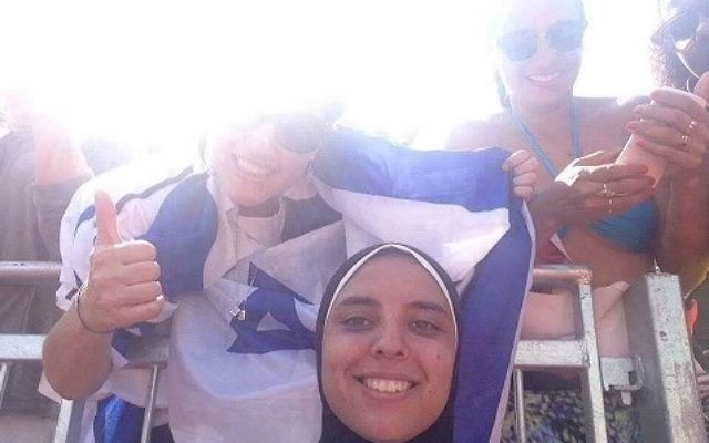 Doaa Elghobashy, joueuse olympique de beach-volley égyptienne, sourit sur une photo alors qu'une femme enveloppée dans le drapeau israélien est derrière elle, en août 2016. (Crédit : Facebook)