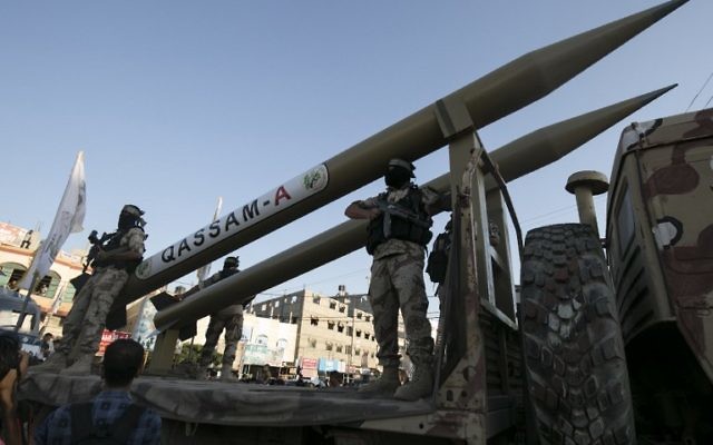 Des membres des Brigades Ezzedine al-Qassam, la branche armée du Hamas, devant leurs roquettes Qassam pendant une cérémonie marquant le deuxième anniversaire de l'assassinat des commandants militaires du Hamas Mohammed Abu Shamala et Raed al-Attar lors d'une parade militaire anti-Israël à Rafah, dans le sud de la bande de Gaza, le 21 août 2016. (Crédit : Saïd Khatib/AFP)