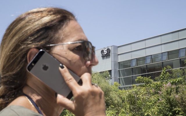 Une Israélienne utilise son iPhone face au bâtiment abritant le firme de cyber-sécurité israélienne NSO Group, le 28 août 2016 à Herzliya. (Crédit : AFP Photo / Jack Guez) Une Israélienne utilise son iPhone face au bâtiment abritant le firme de cyber-sécurité israélienne NSO Group, le 28 août 2016 à Herzliya. (Crédit : AFP Photo / Jack Guez)