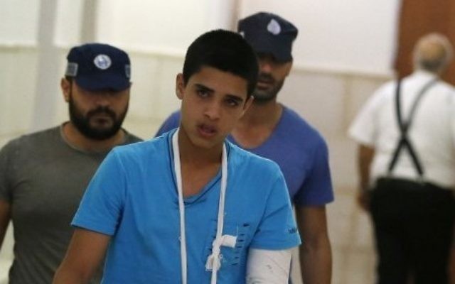 Ahmed Manasra (au premier plan), adolescent palestinien de 14 ans, a été jugé coupable de tentative de meurtre à l'encontre de deux jeunes Israéliens pendant une attaque au couteau en octobre 2015, à sa sortie du tribunal de Jérusalem, le 25 septembre 2016. (Crédit : Ahmad Gharabli/AFP) Ahmed Manasra (au premier plan), adolescent palestinien de 14 ans, a été jugé coupable de tentative de meurtre à l'encontre de deux jeunes Israéliens pendant une attaque au couteau en octobre 2015, à sa sortie du tribunal de Jérusalem, le 25 septembre 2016. (Crédit : Ahmad Gharabli/AFP)