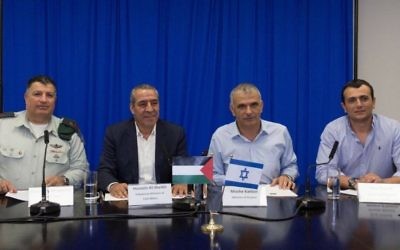 De gauche à droite, le directeur du COGAT, Yoav Mordechai, le ministre palestinien des Affaires étrangères, Hussein al-Sheik, le ministère israélien des Finances Moshe Kahlon et son directeur général Shai Babad signent un accord de résolution de la dette palestinienne électrique de deux milliards de shekels, le 12 septembre 2016. (Crédit : Facebook/COGAT)