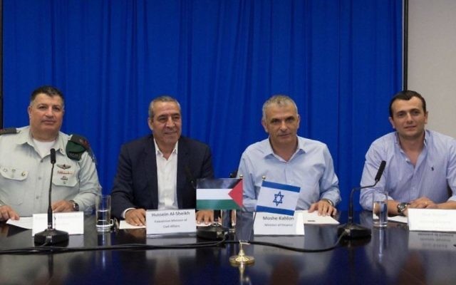 De gauche à droite, le directeur du COGAT, Yoav Mordechai, le ministre palestinien des Affaires étrangères, Hussein al-Sheik, le ministère israélien des Finances Moshe Kahlon et son directeur général Shai Babad signent un accord de résolution de la dette palestinienne électrique de deux milliards de shekels, le 12 septembre 2016. (Crédit : Facebook/COGAT)