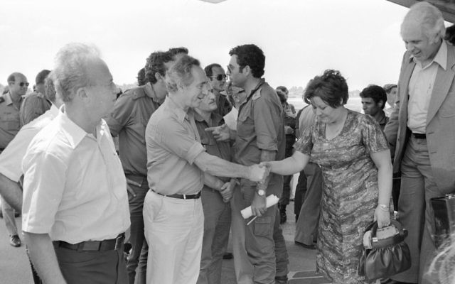 Shimon Peres, alors ministre de la Défense, et l'ancien Premier ministre Yitzhak Rabin, rencontrent les otages libérés d'Entebbe à leur atterrissage en Israël, le 4 juillet 1976. (Crédit : Uri Herzl Tzchik/unité des porte-paroles de l'armée israélienne/archives du ministère de la Défense)