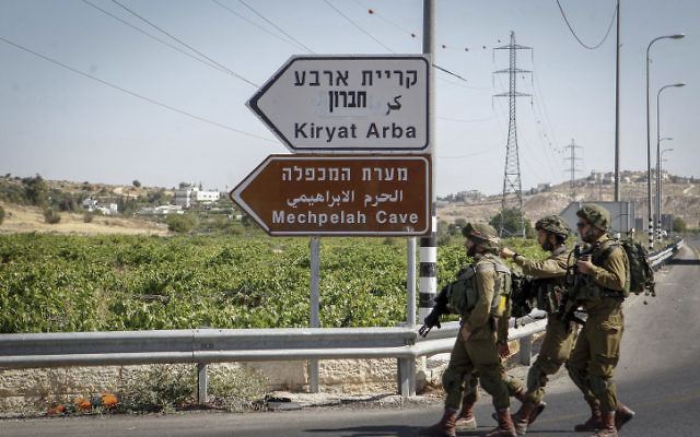 Des soldats israéliens patrouillent près de l'entrée de Kiryat Arba, en Cisjordanie, le 30 juin 2016. (Crédit : Wisam Hashlamoun/Flash90)