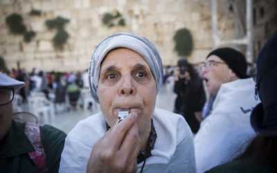 Une femme ultra-orthodoxe siffle pour protester contre l'office de Rosh Hodesh [un nouveau mois juif] des Femmes du Mur, au mur Occidental, dans la Vieille Ville de Jérusalem, le 7 juillet 2016. (Crédit : Hadas Parush/Flash90)