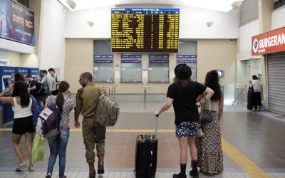 Les voyageurs à la gare centrale de Savidor à Tel Aviv regardant les horaires, où aucun train vers le nord sont indiqués, le 3 septembre 2016 (Crédit : Tomer Neuberg / Flash90)