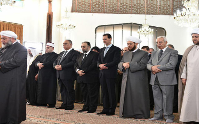 Le président syrien Bashar el-Assad (4° à droite) pendant les prières de l'Aïd al-Fitr à Homs, le 6 juillet 2016. (Crédit : SANA) Le président syrien Bashar el-Assad (4° à droite) pendant les prières de l'Aïd al-Fitr à Homs, le 6 juillet 2016. (Crédit : SANA)