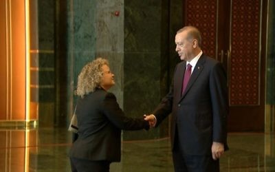 Shani Cooper, attachée diplomatique de la mission israélienne à Ankara, serre la main du président turc Recep Tayyip Erdogan pendant une réception dans la capitale turque, le 30 août 2016. (Crédit : présidence turque)