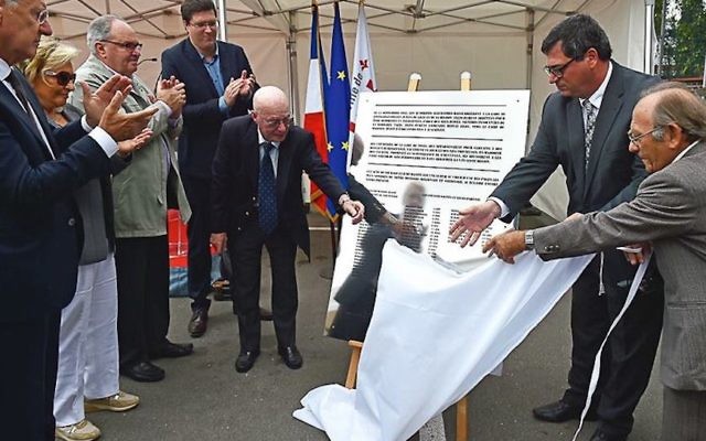 Jacques Stuzalft, à gauche, aide à dévoiler une plaque rappelant le sauvetage des enfants juifs de Lille, en France, par les travailleurs des chemins de fer locaux lors d'une cérémonie dans la ville française du nord, le 9 septembre 2016. (Crédit : Ville de Lille, via Facebook)