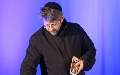 Le Grand Rabbin de France Haim Korsia allume des bougies le 9 janvier 2016 à proximité de l'Hyper Cacher (Crédit : Jacques Demarthon/Pool/AFP)