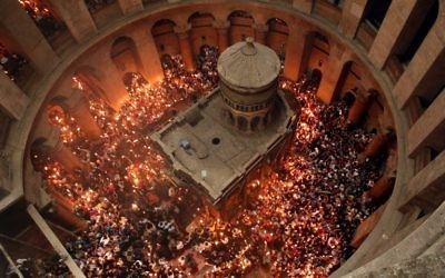 Des fidèles chrétiens orthodoxes allument des bougies dans l'église du Saint-Sépulcre de la Vieille Ville de Jérusalem, pendant la Pâque orthodoxe, le 30 avril 2016. (Crédit : Thomas Coex/AFP)