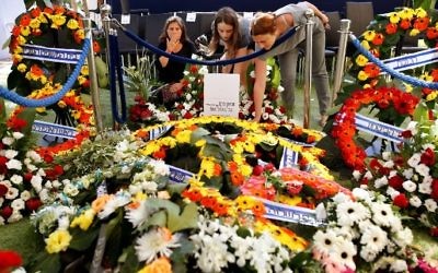 Des Israéliennes sur la tombe de l'ancien président Shimon Peres, après son enterrement au cimetière national du mont Herzl, à Jérusalem, le 30 septembre 2016. (Crédit : AFP/Gil Cohen-Magen)