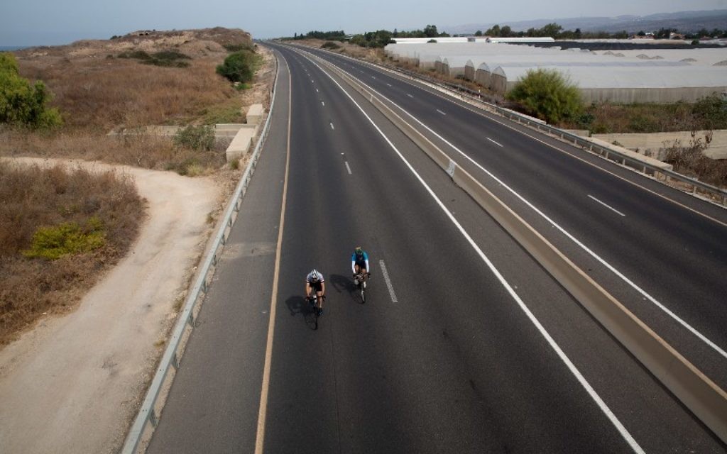 Des Israéliens en vélo sur une autoroute près du moshav Habonim dans le nord d'Israël, à Yom Kippour, le 12 octobre 2016. (Crédit : AFP/Menahem Kahana) Des Israéliens en vélo sur une autoroute près du moshav Habonim dans le nord d'Israël, à Yom Kippour, le 12 octobre 2016. (Crédit : AFP/Menahem Kahana)