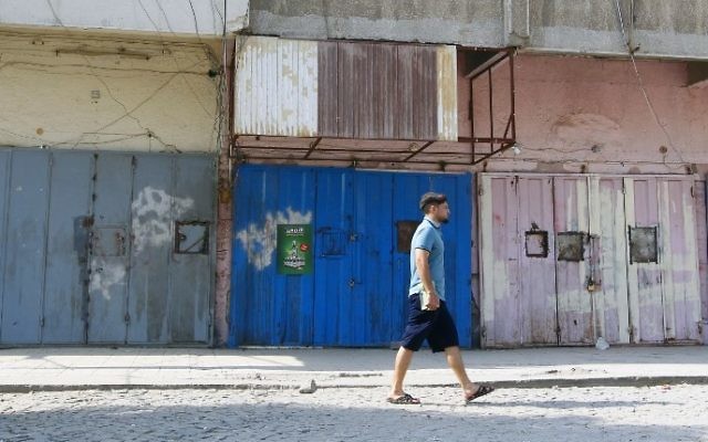Un Irakien passe devant un magasin d'alcool fermé à Bagdad, le 23 octobre 2016. (Crédit : AFP/Sabah Arar)