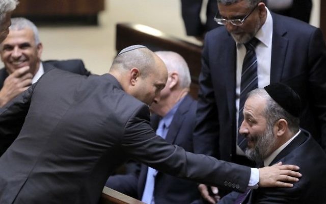 Moshe Kahlon, président de Koulanou (à gauche), Naftali Bennet, chef de HaBayit HaYehudi (au centre) et Aryeh Deri, dirigeant de Shas ( à droite) pendant une session parlementaire où le Premier ministre Benjamin Netanyahu a proposé son gouvernement à un vote de confiance, à la Knesset, le 14 mai 2015. (Crédit : AFP/Pool/Jim Hollander)