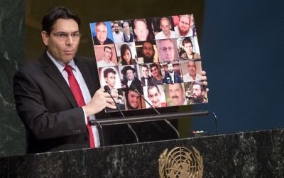 L'ambassadeur d'Israël à l'ONU, Danny Danon, tient un collage de photos des victimes du terrorisme israéliens tués pendant la montée continue de la violence depuis la mi-septembre, le 23 novembre 2015 (Crédit :  ONU / Cia Pak)