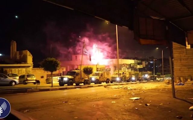 Les troupes israéliennes dans le village d'A-Ram, au nord de Jérusalem, vont fermer le magasin de bonbons possédé par la famille du terroriste qui a tué deux Israéliens dimanche matin à Jérusalem, le 11 octobre 2016. (Crédit : capture d'écran d'une vidéo fournie par l'unité des porte-paroles de l'armée israélienne) Les troupes israéliennes dans le village d'A-Ram, au nord de Jérusalem, vont fermer le magasin de bonbons possédé par la famille du terroriste qui a tué deux Israéliens dimanche matin à Jérusalem, le 11 octobre 2016. (Crédit : capture d'écran d'une vidéo fournie par l'unité des porte-paroles de l'armée israélienne)