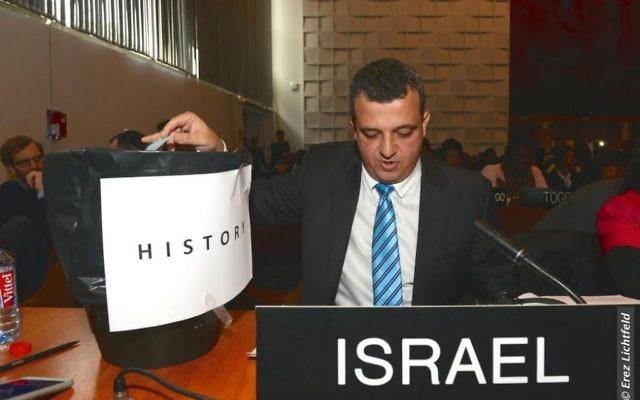 L'ambassadeur israélien auprès de l'UNESCO, Carmel Shama-Hacohen, prend une copie de la résolution tout juste votée à l'UNESCO, et la met à la poubelle de "l'histoire", le 26 octobre 2016. (Crédit : Erez Lichtfeld) L'ambassadeur israélien auprès de l'UNESCO, Carmel Shama-Hacohen, prend une copie de la résolution tout juste votée à l'UNESCO, et la met à la poubelle de "l'histoire", le 26 octobre 2016. (Crédit : Erez Lichtfeld)