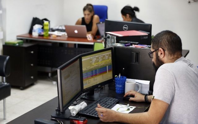 Des Palestiniens dans les bureaux de Red Crow, une start-up qui surveille les évènements sécuritaires et envoie des alertes en temps réel et des cartes à ses clients, à Ramallah, le 17 août 2016. (Crédit : AFP/Abbas Momani)