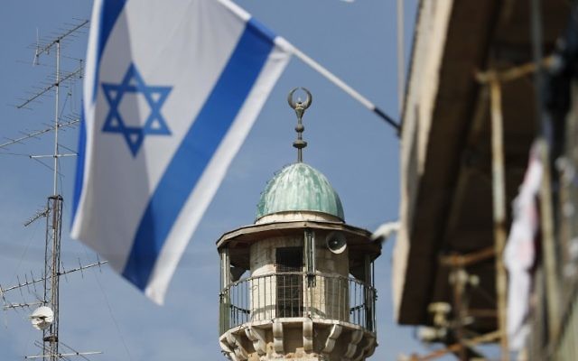 Un drapeau israélien devant un minaret d'une mosquée du quartier musulman de la Vieille Ville de Jérusalem, le 14 novembre 2016. (Crédit : Thomas Coex/AFP) Un drapeau israélien devant un minaret d'une mosquée du quartier musulman de la Vieille Ville de Jérusalem, le 14 novembre 2016. (Crédit : Thomas Coex/AFP)