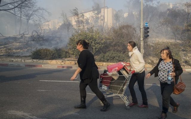 Des Israéliens évacuent leurs domiciles suite aux incendies qui sévissent à Haifa, le 24 novembre 2016 (Crédit : AFP/Jack Guez) Des Israéliens évacuent leurs domiciles suite aux incendies qui sévissent à Haifa, le 24 novembre 2016 (Crédit : AFP/Jack Guez)