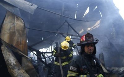 Des pompiers israéliens aident à éteindre un incendie dans la ville du nord de Haïfa le 24 novembre 2016. (Crédit : AFP/Jack Guez) Des pompiers israéliens aident à éteindre un incendie dans la ville du nord de Haïfa le 24 novembre 2016. (Crédit : AFP/Jack Guez)