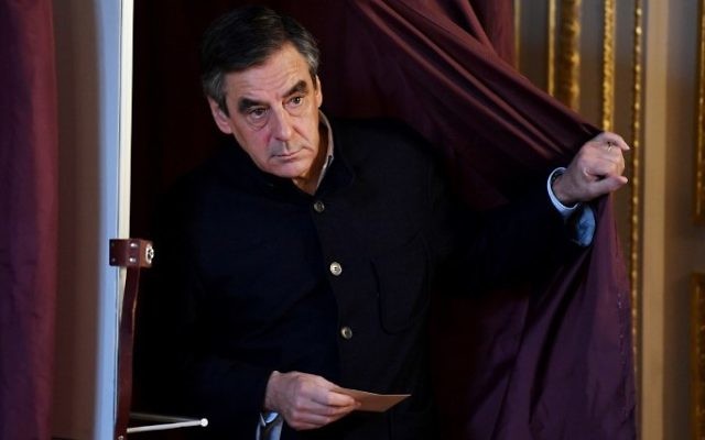 François Fillon, député français et candidat à la primaire de la droite et du centre pour les élections présidentielles françaises de 2017, sort de l'isoloir d'un bureau de vote de Paris, pour le second tour de l'élection, le 27 novembre 2016. (Crédit : Eric Feferberg/Pool/AFP)