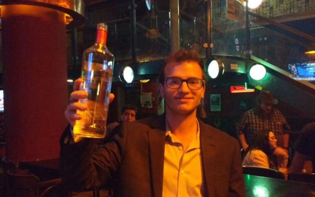 Israel Jacobowitz offre des shots aux partisans de Trump dans un bar de Jérusalem, le 9 novembre 2016. (Crédit : Melanie Lidman/ Times of Israel)