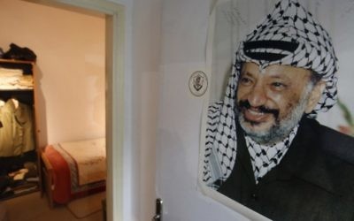 Portrait de l'ancien dirigeant palestinien Yasser Arafat, accroché à la porte d'une reconstitution du lieu où il a vécu ses dernières années, au nouveau musée Arafat de Ramallah, en Cisjordanie, le 9 novembre 2016. (Crédits : Abbas Momani/AFP) Portrait de l'ancien dirigeant palestinien Yasser Arafat, accroché à la porte d'une reconstitution du lieu où il a vécu ses dernières années, au nouveau musée Arafat de Ramallah, en Cisjordanie, le 9 novembre 2016. (Crédits : Abbas Momani/AFP)