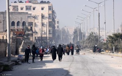 Les civils syriens marchant vers un poste de contrôle tenu par les forces pro-gouvernementales, au rond-point de la rue Al-Hawoz, après avoir quitté les quartiers de l'est d'Alep le 10 décembre 2016 (Crédit : George Ourfalian/AFP) Les civils syriens marchant vers un poste de contrôle tenu par les forces pro-gouvernementales, au rond-point de la rue Al-Hawoz, après avoir quitté les quartiers de l'est d'Alep le 10 décembre 2016 (Crédit : George Ourfalian/AFP)
