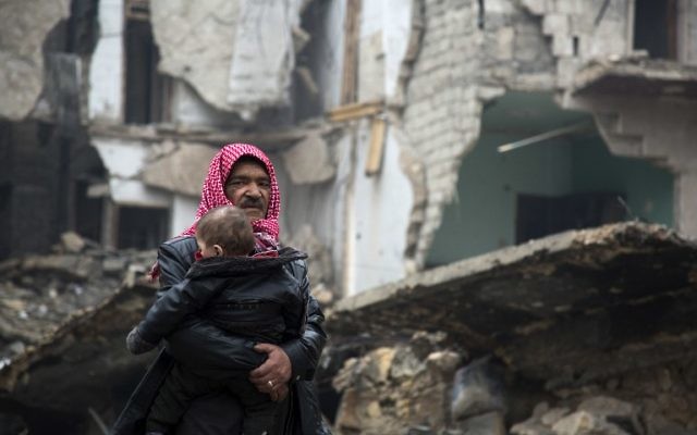 Des Syriens quittent un quartier d'Alep tenu par les rebelles pour la partie sous contrôle gouvernementale pendant une opération des forces du gouvernement syrien pour reprendre la ville assiégée, le 13 décembre 2016. (Crédit : Karam al-Masri/AFP) Des Syriens quittent un quartier d'Alep tenu par les rebelles pour la partie sous contrôle gouvernementale pendant une opération des forces du gouvernement syrien pour reprendre la ville assiégée, le 13 décembre 2016. (Crédit : Karam al-Masri/AFP)