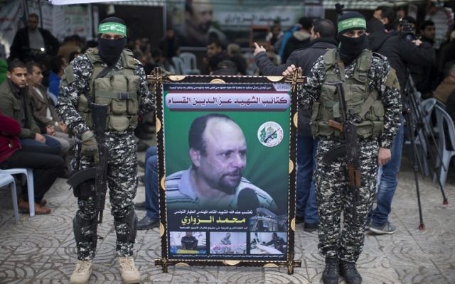 Des membres des Brigades Ezzedine al-Qassam Brigades, la branche armée du Hamas, avec un portrait de Mohammed al-Zoari, qui a été tué en Tunisie, pendant une cérémonie en son honneur dans la ville de Gaza, le 18 décembre 2016. (Crédit : Mahmud Hams/AFP)