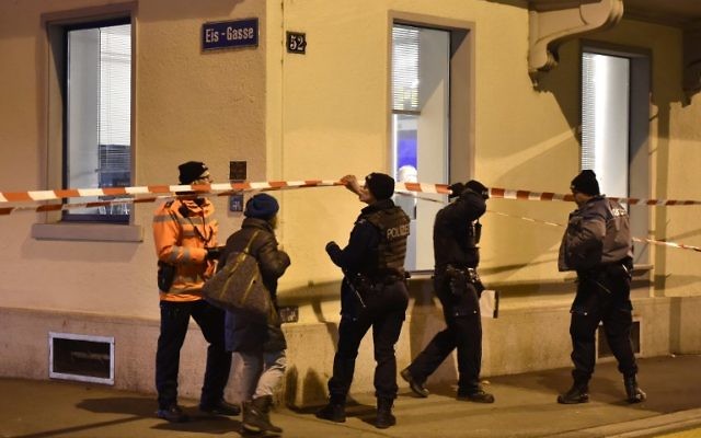 La police suisse derrière un cordon policier disposé devant une salle de prière musulmane dans la rue Eis-Gasse, dans le centre de Zurich, le 19 décembre 2016, après que trois personnes ont été blessées par des coups de feu. (Crédit : MICHAEL BUHOLZER / AFP)