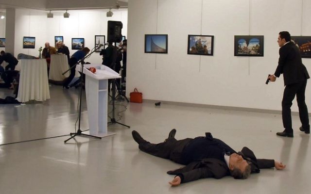 Andreï Karlov, l'ambassadeur de la Russie auprès de la Turquie, gît au sol près de son assassin, qui vise toujours le public d'une exposition à Ankara, le 19 décembre 2016. (Crédit : STRINGER/AFP) Andreï Karlov, l'ambassadeur de la Russie auprès de la Turquie, gît au sol près de son assassin, qui vise toujours le public d'une exposition à Ankara, le 19 décembre 2016. (Crédit : STRINGER/AFP)