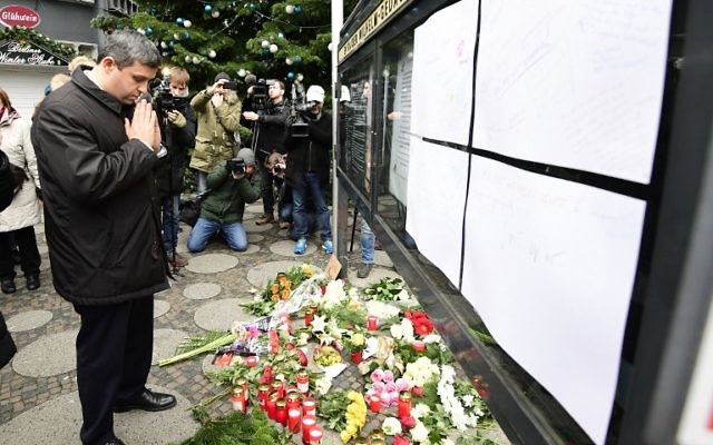 Raed Saleh, le président du groupe social démocrate du SPD au Parlement allemand, prie devant l'église du Souvenir de Berlin, au lendemain d'une attaque au camion bélier contre le marché de Noël de la ville qui a fait au moins 12 morts, le 20 décembre 2016. (Crédit : Tobias Shwarz/AFP)