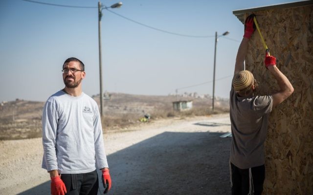 De jeunes hommes juifs construisent une structure dans l'avant-poste d'Amona, en Cisjordanie, le 28 novembre 2016. (Crédit : Hadas Parush/Flash90) De jeunes hommes juifs construisent une structure dans l'avant-poste d'Amona, en Cisjordanie, le 28 novembre 2016. (Crédit : Hadas Parush/Flash90)