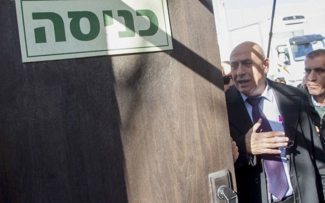 Le membre de la Knesset de la Liste (Arabe) Unie  Basel Ghattas,au centre, arrive aux bureaux de l'unité policière d'enquête Lahav 433 à Lod, le 20 décembre 2016 (Crédit : Roy Alima/Flash90)