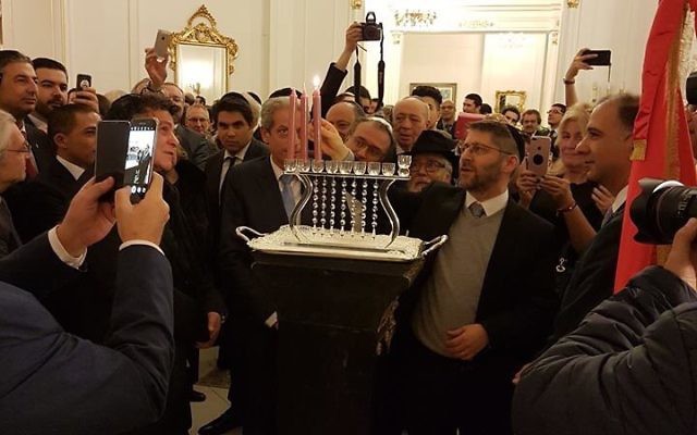 Allumage de la troisième bougie à l'ambassade de Tunisie en présence des représentants des trois cultes, le 26 décembre 2016 (Crédit : Bernard SALAT, Twitter).