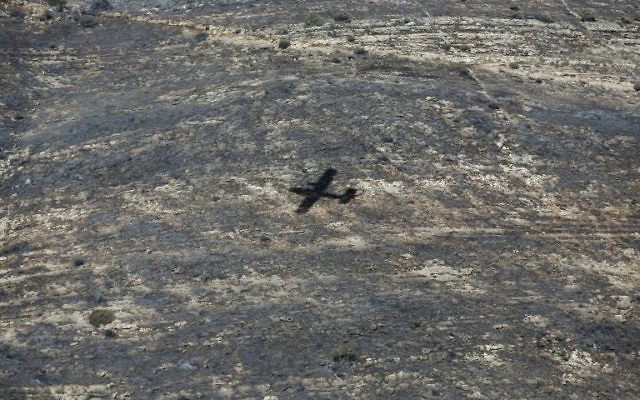 L'ombre d'un bombardier d'eau turc sur le village de Nataf près de Jérusalem, pour aider à maitriser les incendies le 26 novembre 2016. (Crédit : AFP PHOTO / AHMAD GHARABLI) L'ombre d'un bombardier d'eau turc sur le village de Nataf près de Jérusalem, pour aider à maitriser les incendies le 26 novembre 2016. (Crédit : AFP PHOTO / AHMAD GHARABLI)