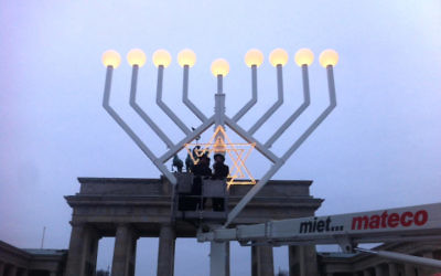 Le rabbin Yehudah Teichtal, à gauche, et un collègue mettent à l'épreuve une menorah de Hanoukka à la porte de Brandenburg à Berlin, le 22 décembre 2016 (Autorisation de Teichtal/via JTA) Le rabbin Yehudah Teichtal, à gauche, et un collègue mettent à l'épreuve une menorah de Hanoukka à la porte de Brandenburg à Berlin, le 22 décembre 2016 (Autorisation de Teichtal/via JTA)