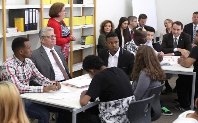 Photo d'illustration : Le président allemand Joachim Gauck (au centre) rencontre de jeunes réfugiés durant sa visite au centre de formation professionnel Friedrich-Feldà Giessen, au centre de l'Allemagne, le 17 juin 2015 (Crédit :Daniel Roland/AFP) Photo d'illustration : Le président allemand Joachim Gauck (au centre) rencontre de jeunes réfugiés durant sa visite au centre de formation professionnel Friedrich-Feldà Giessen, au centre de l'Allemagne, le 17 juin 2015 (Crédit :Daniel Roland/AFP)