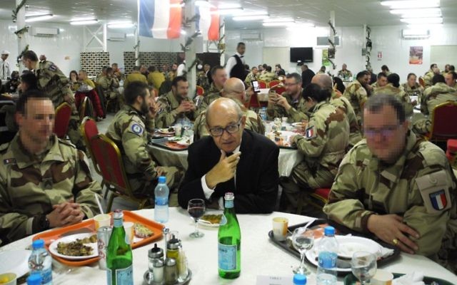 Le (vrai) ministre français de la Défense, Jean-Yves Le Drian, au centre, entourés des soldats de l'armée de l'air française sur une base militaire de Jordanie, le 31 décembre 2016. (Crédit : Valérie Leroux/AFP) Le (vrai) ministre français de la Défense, Jean-Yves Le Drian, au centre, entourés des soldats de l'armée de l'air française sur une base militaire de Jordanie, le 31 décembre 2016. (Crédit : Valérie Leroux/AFP)